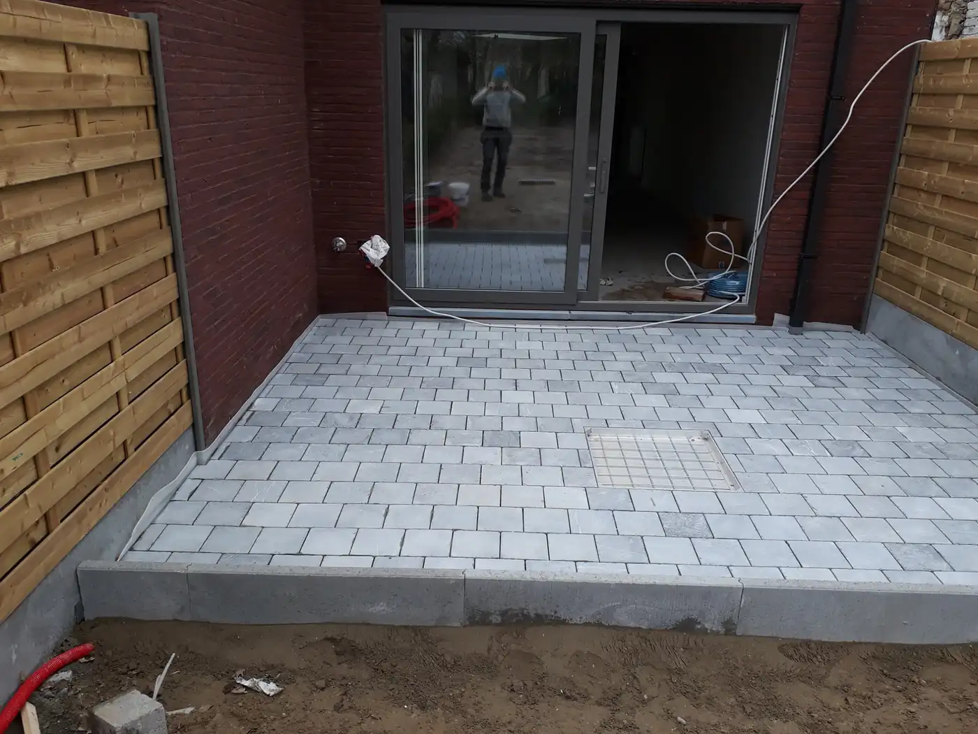 Aangelegd terras in keramische tegels bij een woning in West-Vlaanderen